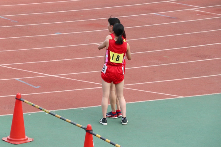 女子5000m完走後の福井選手のゼッケンを外している筒井選手